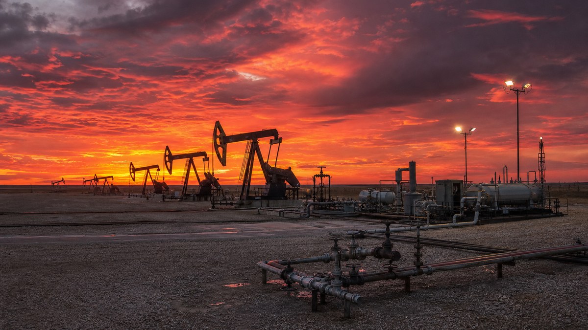 Gas compression and injection equipment on a Bakken well pad at dusk for enhanced oil recovery in North Dakota