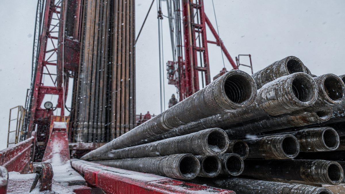 Stands of drill pipe racked on a drilling rig floor in the Bakken on a snowy overcast day